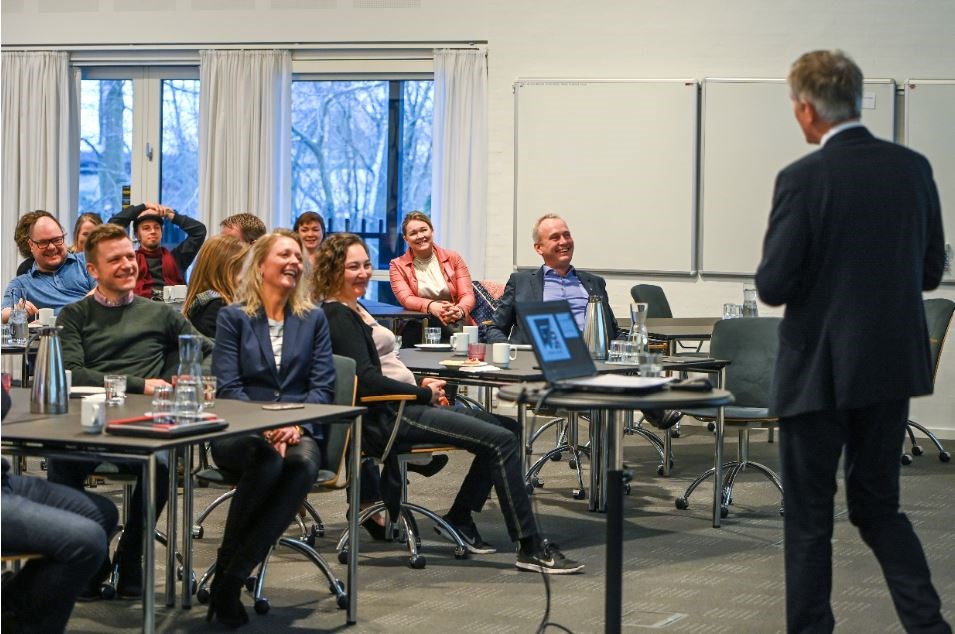 Der var brede smil over hele linjen, da Peter Vinther Christensen, holdt sin tale på morgenmødet i anledningen af Finansektorens Udannelsescenters 50-års jubilæum.